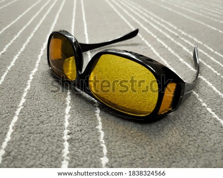Picture of yellow glasses on a gray carpet. Pictures are taken from various angles of the glasses.