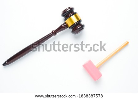 A flatlay picture of gavel and toy hammer on copyspace white background for ambition concept. The ambition of this kid to be a law judge.