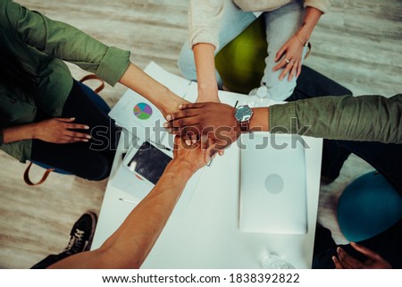 Business colleagues stacking hands together creating team unity preparing for presentation to boss and managers 