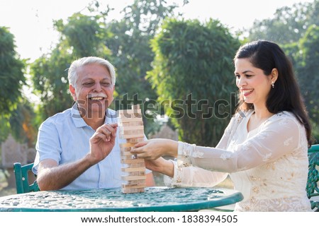 Father and daughter playing with wood blocks.