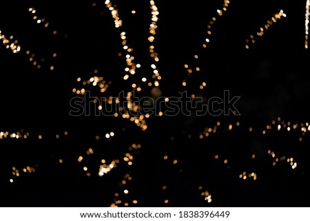 Bright stripes of fireworks with smoke and bokeh on a black background.
