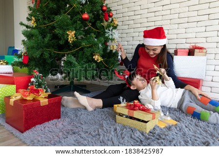 mother and cute daughter feeling happy and enjoy with gift box beside Christmas tree