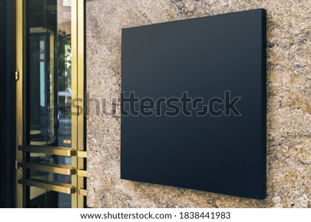 Black square signboard on the marble wall of a modern business center, mock up Royalty-Free Stock Photo #1838441983