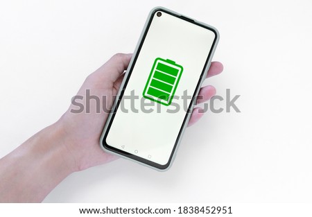 Man's hand holding black smartphone isolated on white background. A fully charged smartphone battery. charge level indicator.