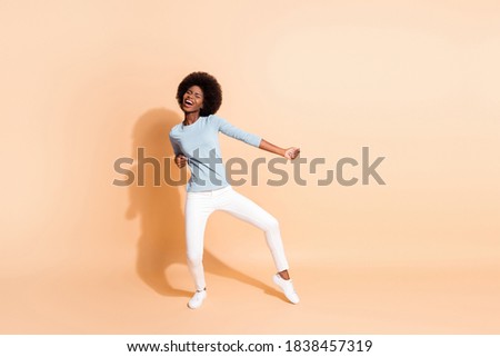 Photo portrait full body view of african american woman dancing enjoying party isolated on pastel beige colored background
