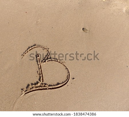 Drawing the letter B on the sand