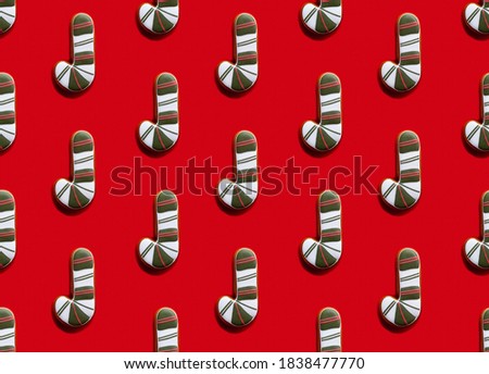 Christmas cane pattern. Red seamless background. Winter holidays adornment. Green white striped art lollipop minimalist symmetrical composition isolated on bright.