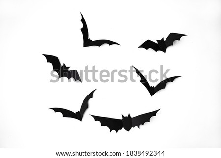 halloween, decoration and scary concept - black paper bats flying over white background. Halloween paper bats on white background. Halloween decorations on white background. Halloween concept.