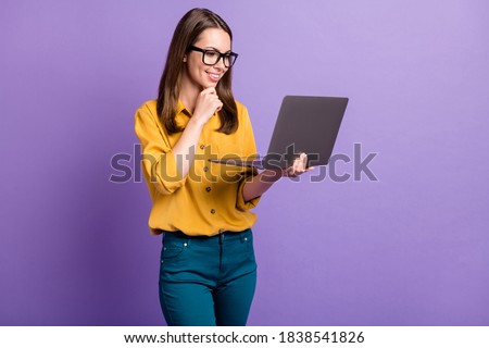 Photo of pretty young girl arm chin hold computer toothy smile wear glasses yellow shirt blue pants isolated violet color background