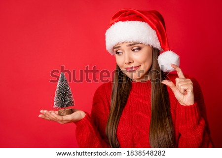 Close-up portrait of her she nice attractive charming girl holding in hands tiny pitiful festal tree decor showing size isolated over bright vivid shine vibrant red color background