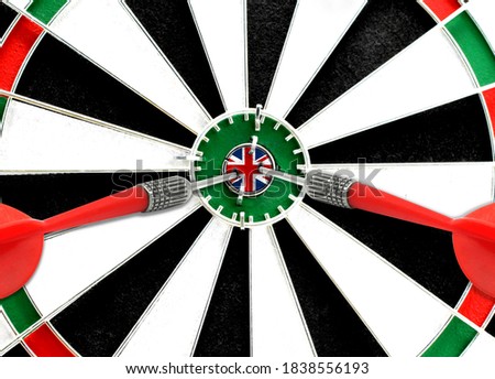 Close-up of a dart board with an imprinted flag of United Kingdom in the center. The concept of achieving goals.