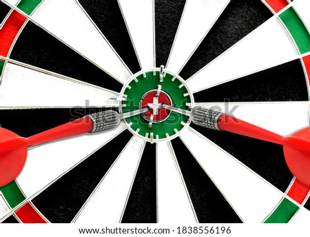 Close-up of a dart board with an imprinted flag of Switzerland in the center. The concept of achieving goals.