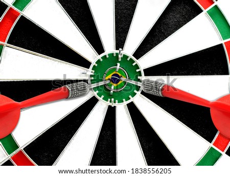 Close-up of a dart board with an imprinted flag of Brazil in the center. The concept of achieving goals.