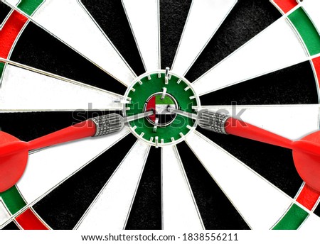 Close-up of a dart board with an imprinted flag of United Arab Emirates in the center. The concept of achieving goals.