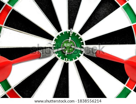 Close-up of a dart board with an imprinted flag of Saudi Arabia in the center. The concept of achieving goals.