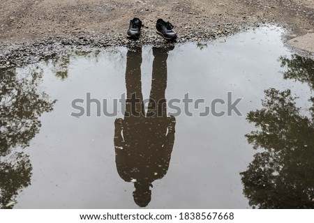 Shoes with shadow without the human / Reflection of shadow. Invisible man. Reflection of a man in a puddle. Royalty-Free Stock Photo #1838567668