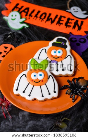 A couple (girl and boy)of funny, amusing  spiders painted on honey gingerbread. Halloween food.