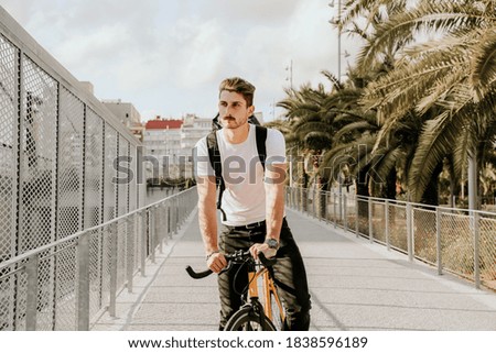 Portrait of content young man riding his racing cycle in the city.