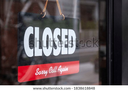 Closed sign hanging on the glass door in front of the restaurant