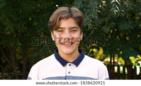 Close-up of the face of a young, cute, Caucasian boy who smiles broadly at the camera. Positive emotion. On the street Royalty-Free Stock Photo #1838620921