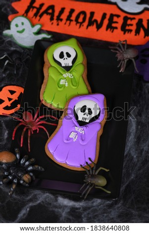 Painted Ghost in cape hooded on a honey gingerbread cookies. Halloween food.