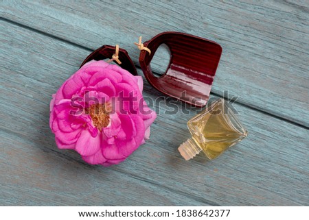 Damask rose and perfume bottle isolated on a white background.