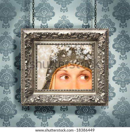 Silver picture frame hung against floral wallpaper background/ blue