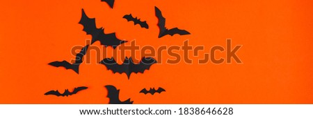 Halloween concept. Festive decorations. Bats on an orange background. Banner format