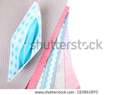 Origami boat and color papers isolated on white