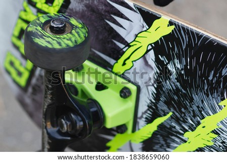 Beautiful skate in black and light green colors. Skateboard wheel close-up.