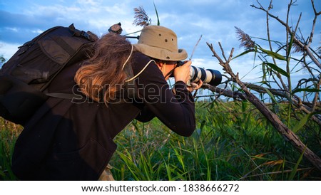 photographer taking pictures of wildlife with a telephoto lens
