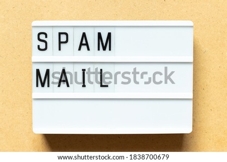 Lightbox with word spam mail on wood background