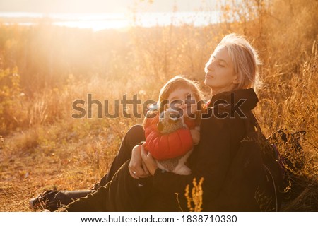 happy family Mom and the little daughter hug and play in autumn outdoor at sunset. family time together.  Stay cations, hyper-local travel,  family outing, 