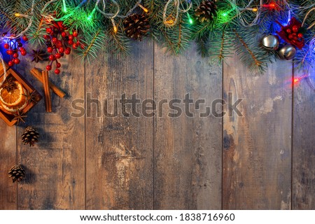 Christmas and New Year wooden background with light. Art Christmas Greeting Card. Christmas lights bulb decoration on dark wood plank. Merry Christmas and New Year holiday background. top view.