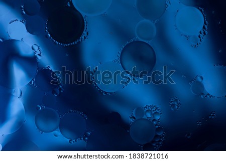 Blue glitter vintage lights background. Blue texture background. Oil drops in water.