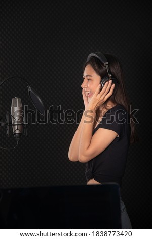 asian  lady singing in music studio record room
