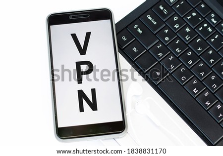 phone with text acronym VPN Virtual Private Network on laptop keyboard.