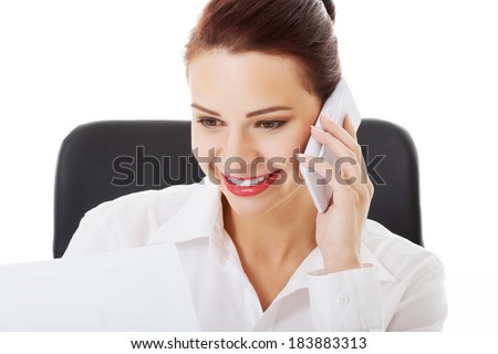 Beautiful business woman sitting and talking through phone. Isolated on white.