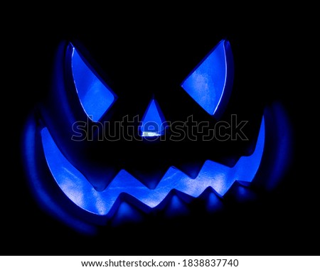 Illuminated Halloween pumpkin photographed on a black background.