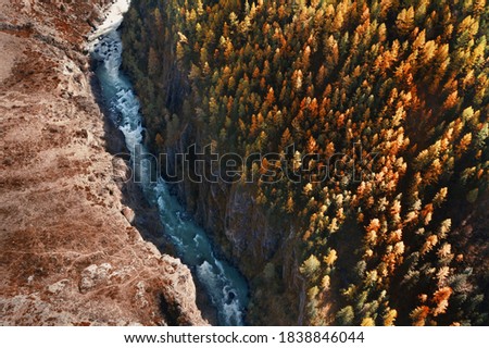 Autumn mountain valley, blue river, orange and green forest. Aerial drone  view
