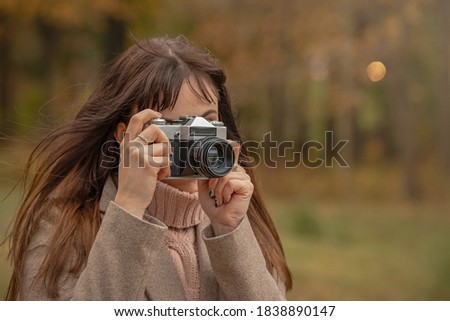 girl photographs on a vintage camera, travel photographer, young woman with a camera on the street, portrait of a close-up
