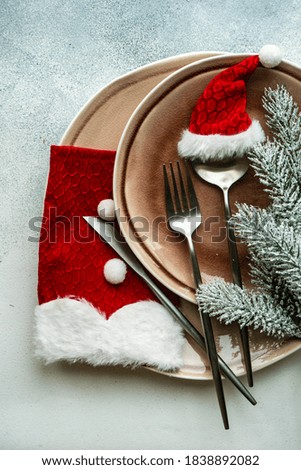 Festive place setting for celebration the Christmas eve on concrete table