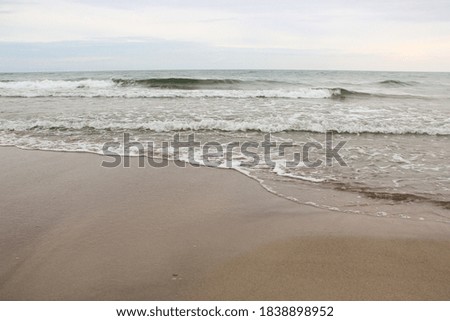 Sandy beach and small calm waves by the Polish sea (Mielenko)