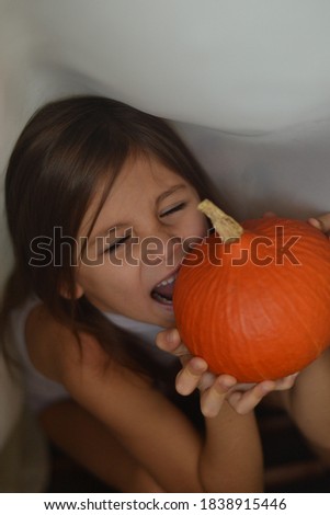 funny girl bites a small pumpkin
halloween