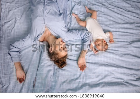 Mom and newborn sleep together in the bedroom on the bed. Joint sleep concept. Tired parent. Natural Parenting care. Silence is calm. Motherhood baby togetherness. Real life lifestyle Royalty-Free Stock Photo #1838919040