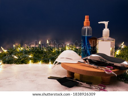 Greeting card Happy New Year and Merry Christmas for a hairdresser and barber shop with face mask , hand sanitizer, Barber Clippers, scissor. Copy space.