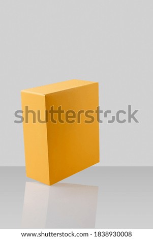 Yellow orange closed cardboard box or carton on grey background, template, mockup, sideview.