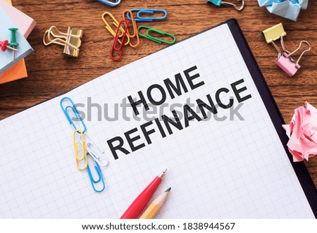 Notepad with text Home Refinance on wooden background with paper clips and pen