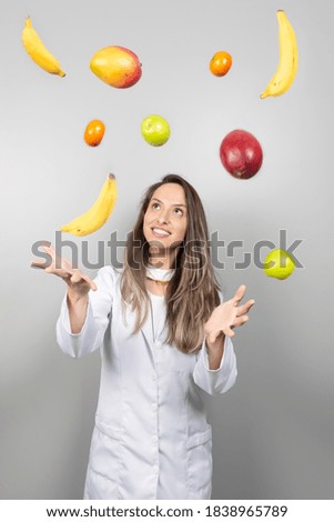 Smiling female nutritionist juggling with oranges. Healthcare and diet concept. Lifestyle.