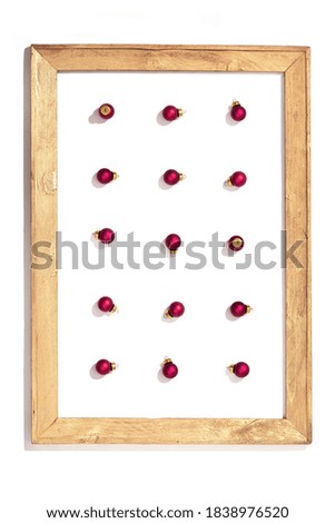 Christmas background with falls red small balls in wooden painted frame isolated in white. Beautiful New Year and Winter Holiday concept. 